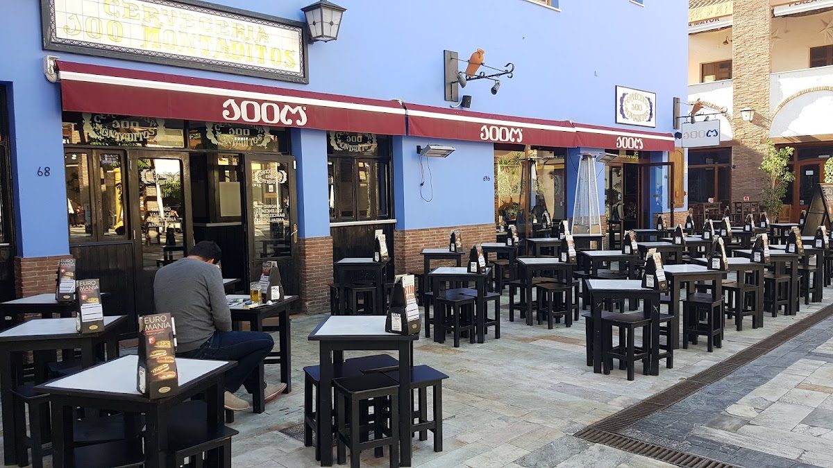 Outdoor seating area of 100 Montaditos with black tables and chairs in Churriana, Málaga.