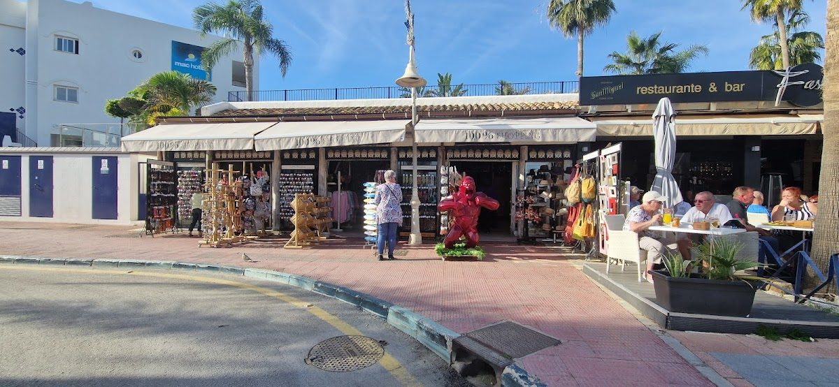 El centro comercial 100 % Shopping ofrece coloridos souvenirs y artículos decorativos en el exterior, con un restaurante cercano en Puerto Marina.