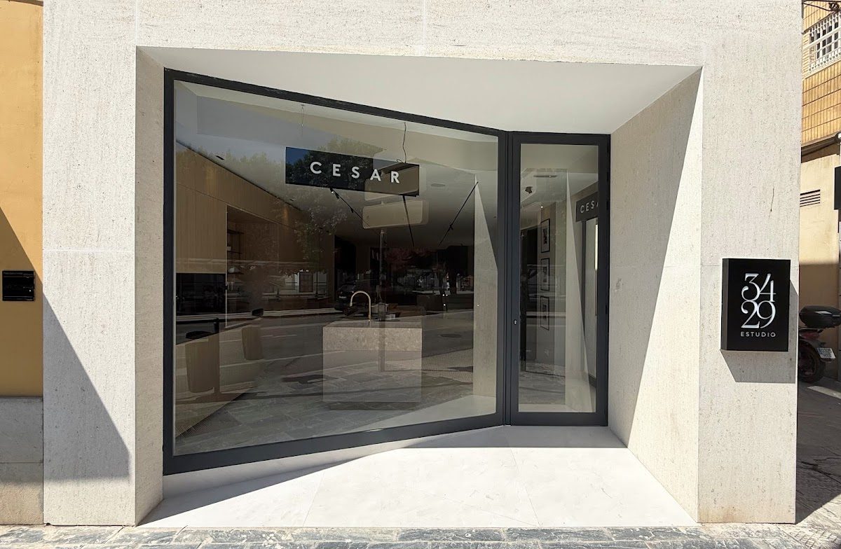 The exterior of 34·29 Estudio features a modern design with large glass windows and a sleek sign.