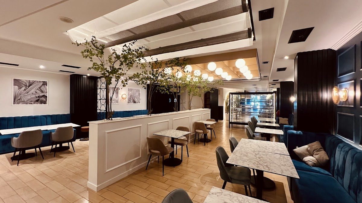 Modern interior of 6700 by Bacus featuring blue seating, marble tables, and decorative lighting.
