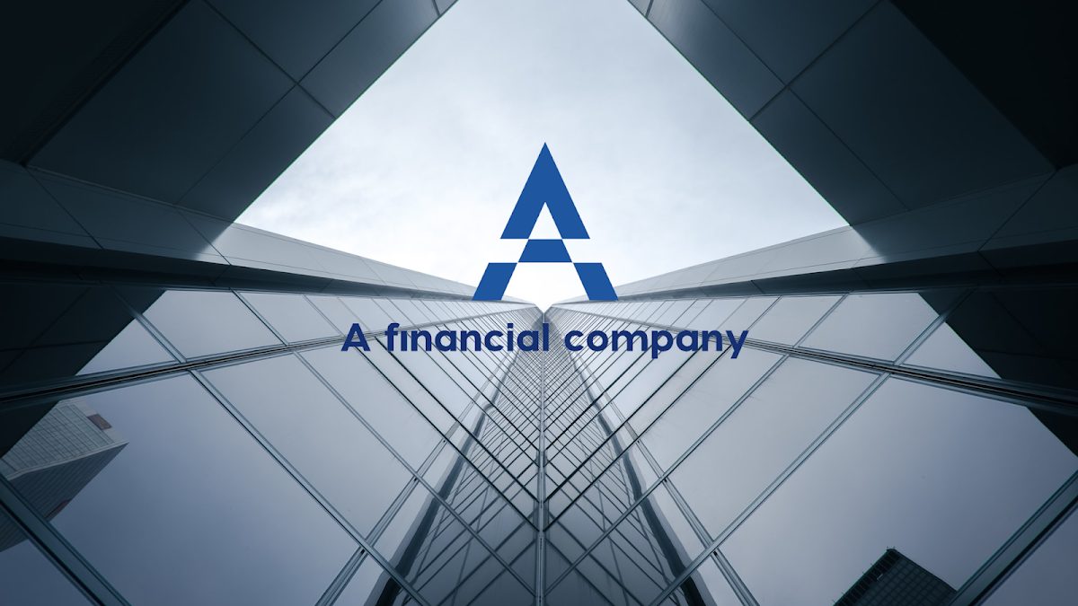 La imagen muestra un moderno edificio de cristal con el logotipo de una empresa financiera prominentemente exhibido.