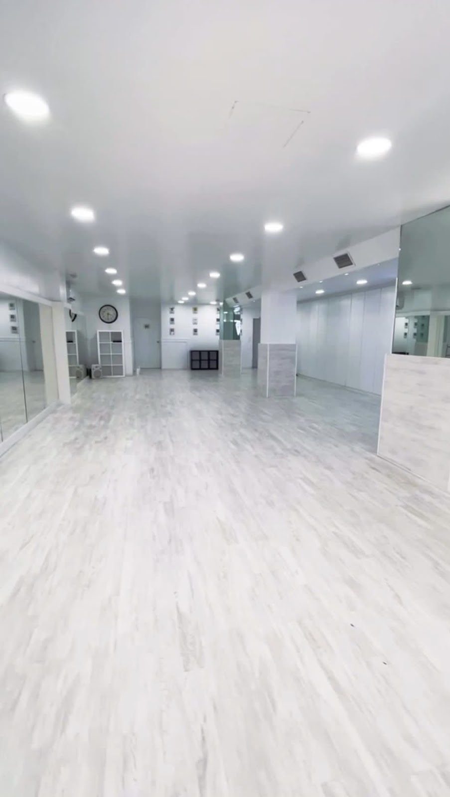 Spacious, bright dance studio with white walls and wooden flooring at Academia de Danza Diamonds.