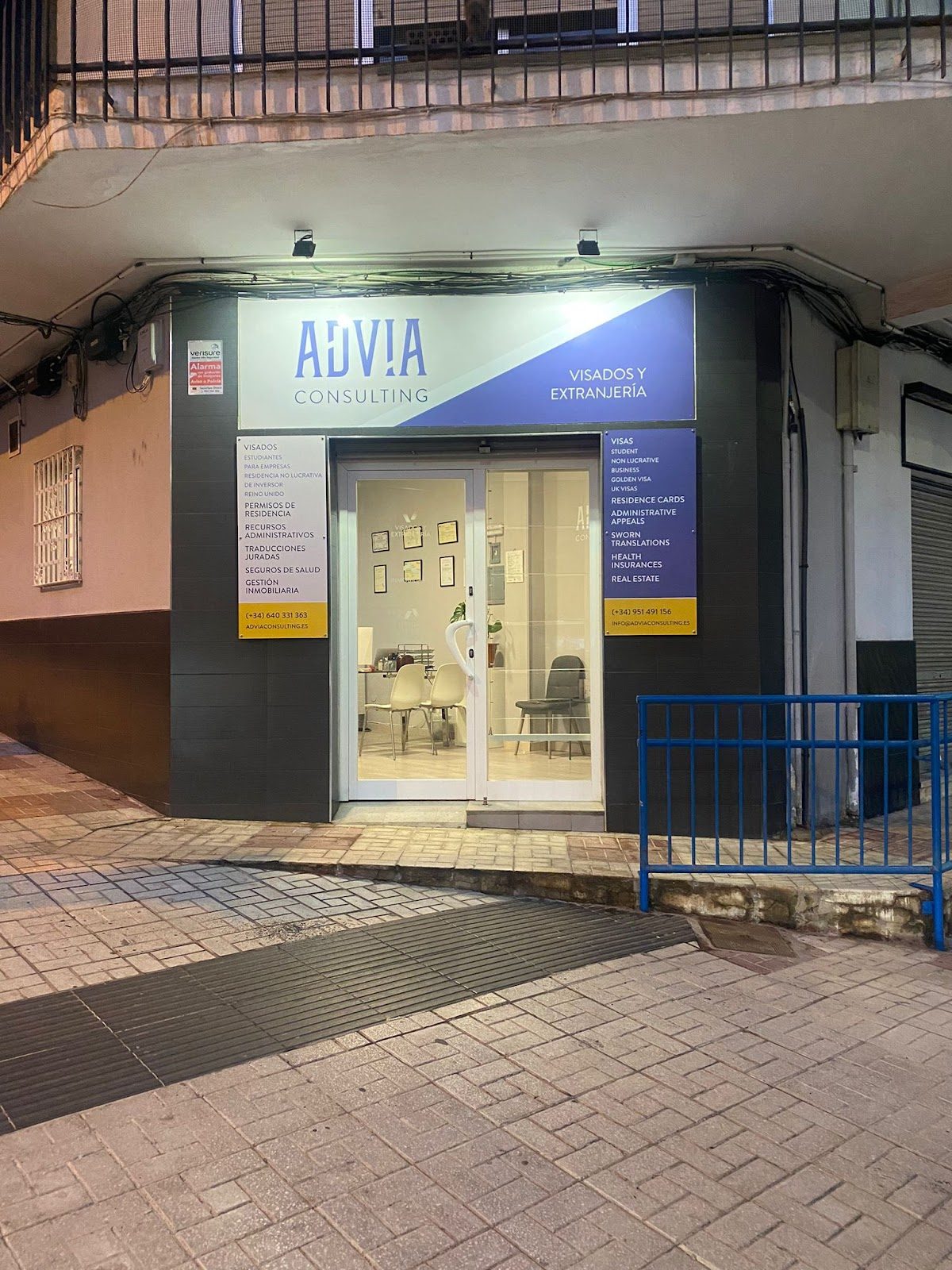 Exterior de la oficina de Advia Consulting - Extranjería con señalización y entrada de cristal en Málaga.