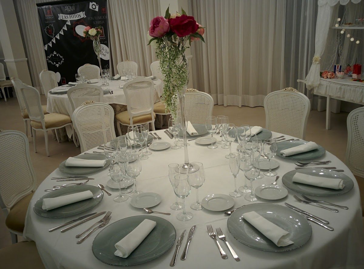 Elegante mesa en Alborada Innoeventos con mantel blanco, cristalería y centro de mesa floral.