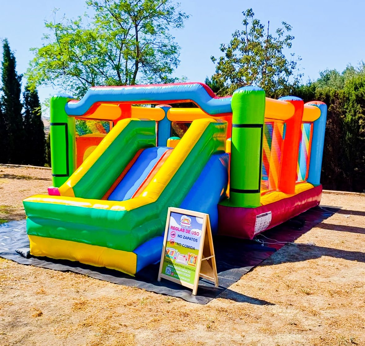 Castillo hinchable de colores con toboganes, instalado al aire libre en un día soleado en Juegalandia, en Las Lagunas de Mijas.