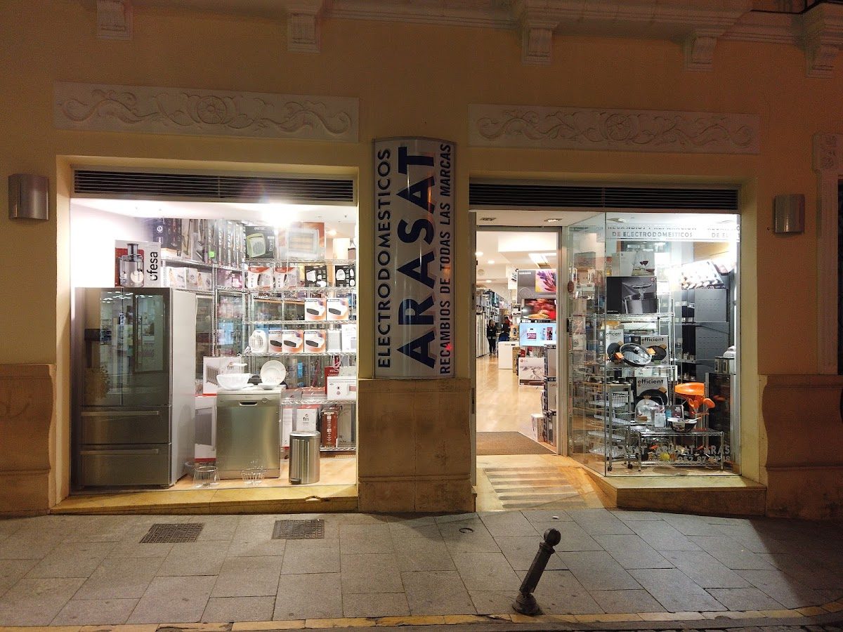 La tienda Arasat ofrece una variedad de electrodomésticos y muebles expuestos en un escaparate bien iluminado.