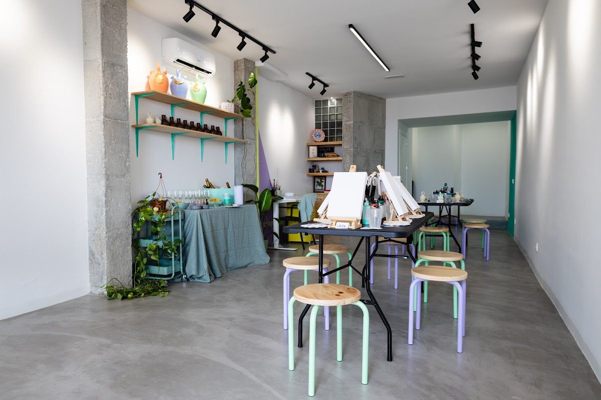 Artelier 21 features a bright, minimalist art studio with easels, tables, and colorful chairs.