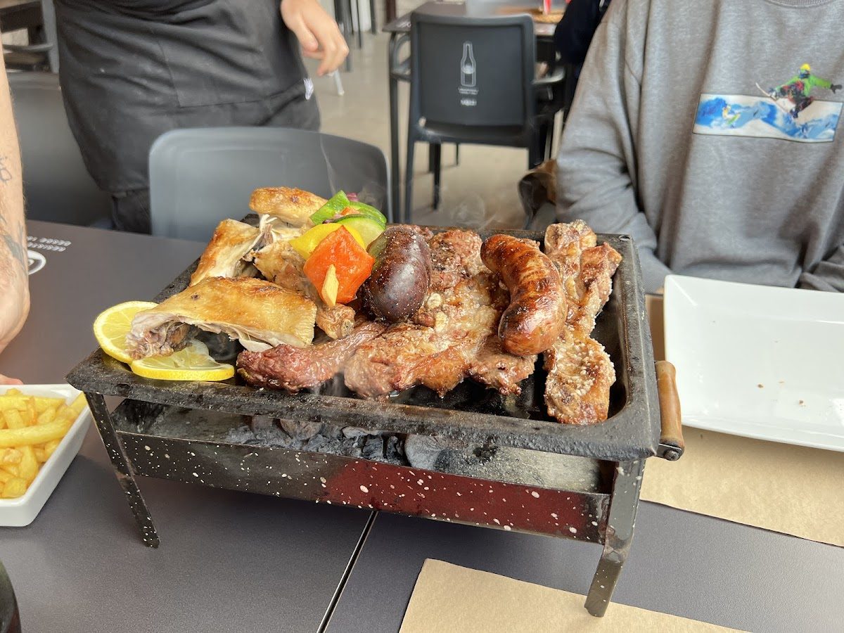 A sizzling platter of grilled meats and vegetables served at Asador la Granja.