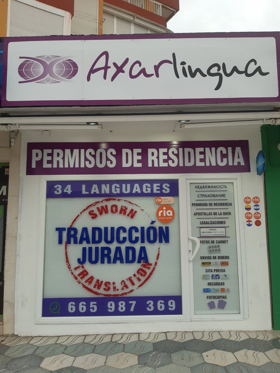 Fachada de una tienda AXARLINGUA con un letrero que anuncia servicios de traducción y permisos de residencia en varios idiomas.