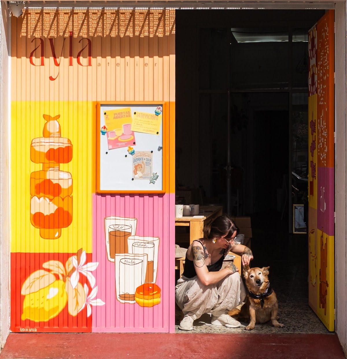 Ayla Atelier cuenta con una entrada colorida decorada con la imagen de una mujer y un perro, y con vibrantes obras de arte en las paredes.