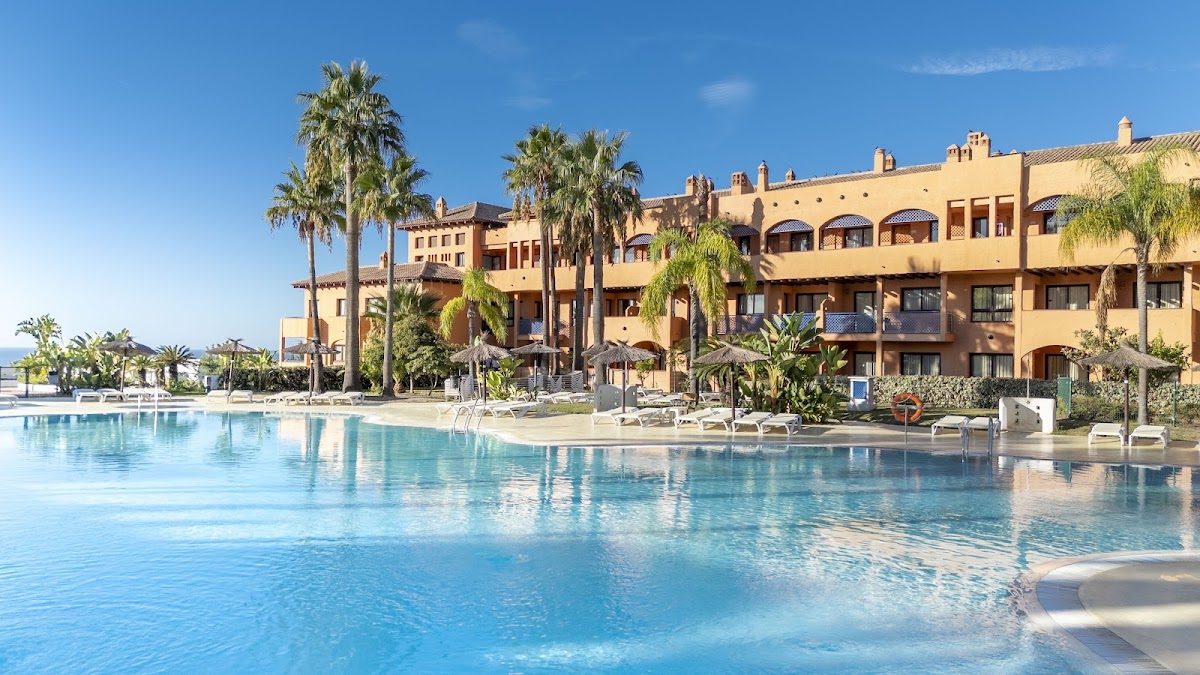 El Bakour Oh Nice Costa del Sol cuenta con una amplia zona de piscina rodeada de palmeras y un elegante exterior.