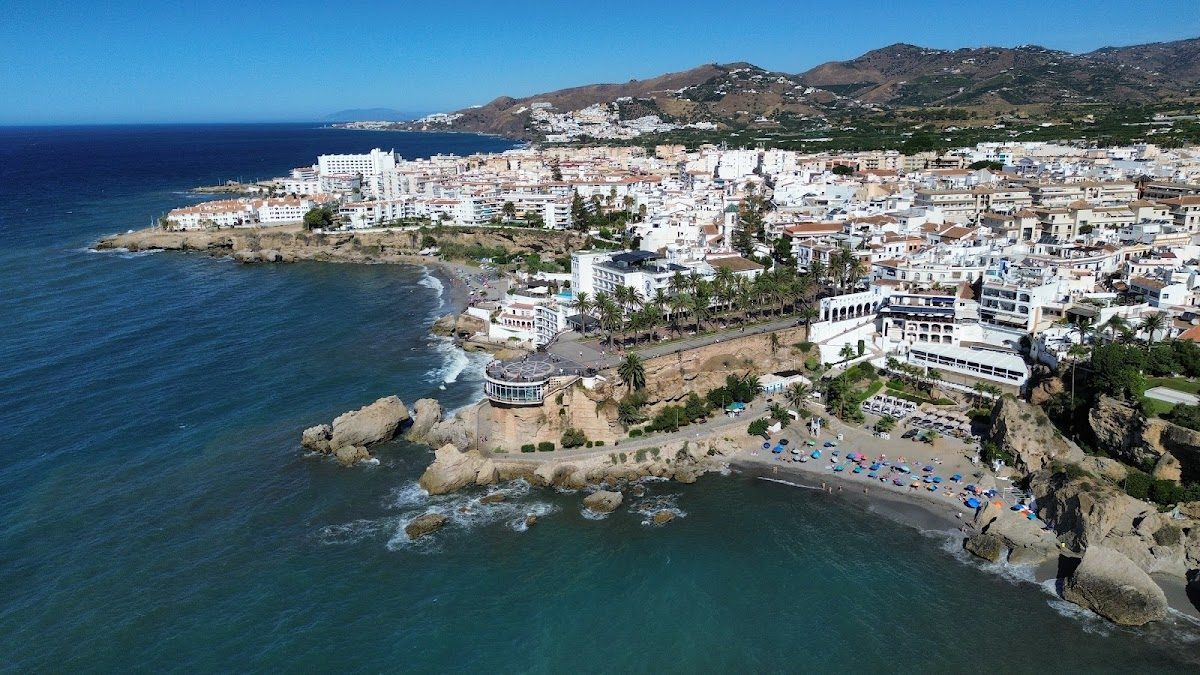 Aerial view of Balcón de Europa, showcasing coastal scenery, beach, and surrounding buildings in Nerja.