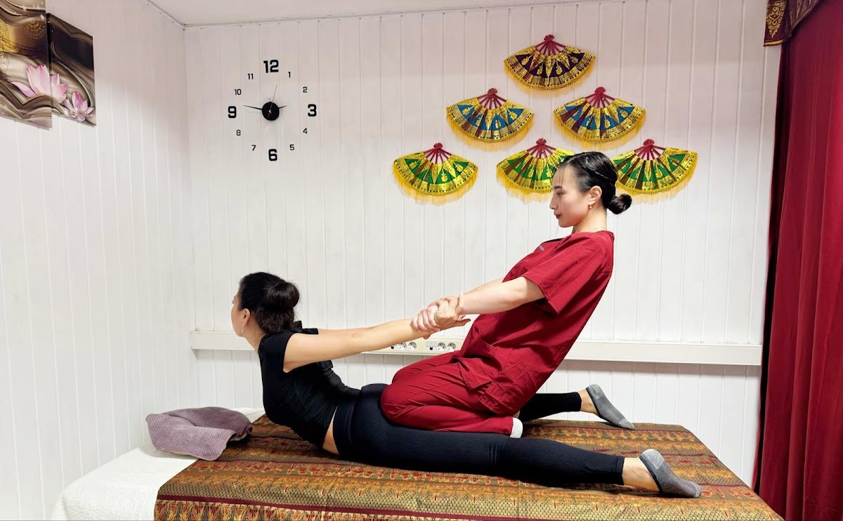 A therapist performs a massage on a client in a serene treatment room at Bali Thai Spa & Beauty Wellness.