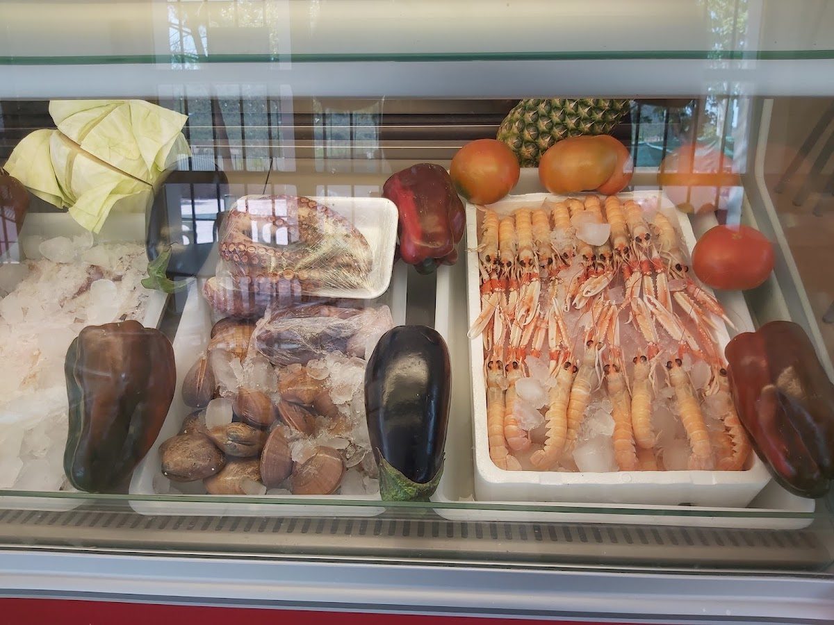 Fresh seafood display featuring shrimp, octopus, clams, and vegetables at Bar El Ladrón Antequera.