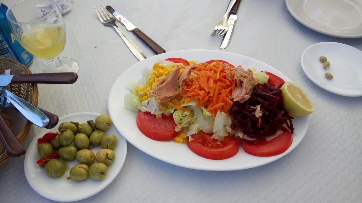 En Bar La Bodega, podrá degustar una colorida ensalada con atún, tomates, maíz y zanahorias, servida con aceitunas y una rodaja de limón.