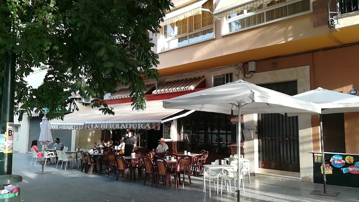 Bar la Herradura de El Palo features outdoor seating with umbrellas and a welcoming entrance in Málaga.