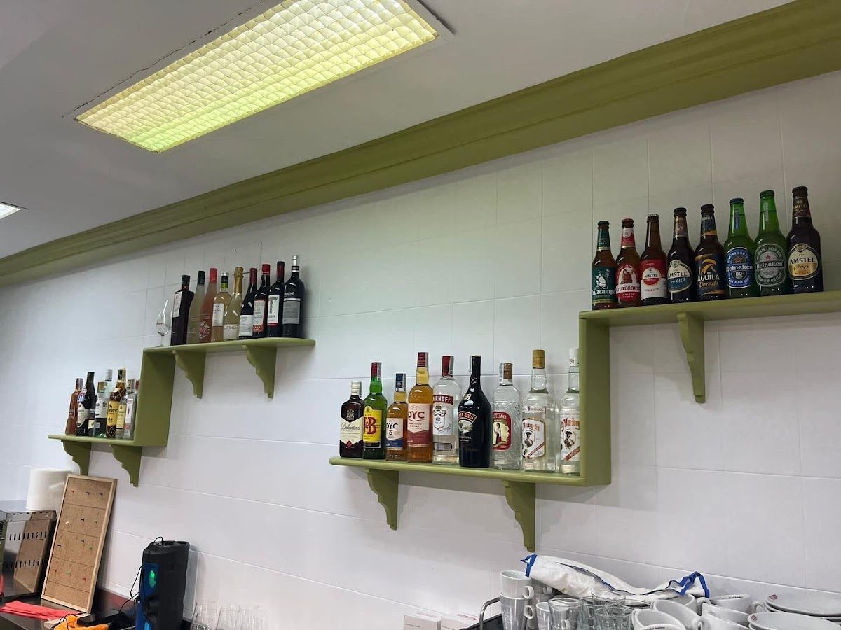 El bar Los Verdiales cuenta con estanterías repletas de botellas de diversos licores y cervezas.