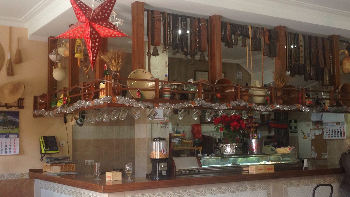 The interior of Bar Tapeo Tito Pepe features a wooden bar with decorative items and a festive star hanging above.