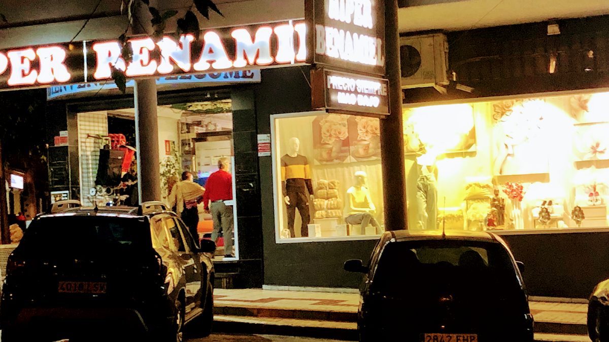 El bazar Hiper Benamiel cuenta con una fachada muy iluminada, con diversos artículos expuestos y clientes entrando.
