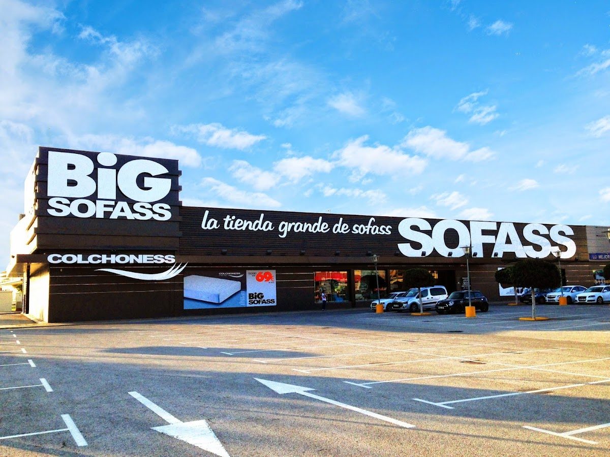 Exterior de la tienda BiGSOFASS con gran letrero y una amplia zona de aparcamiento.