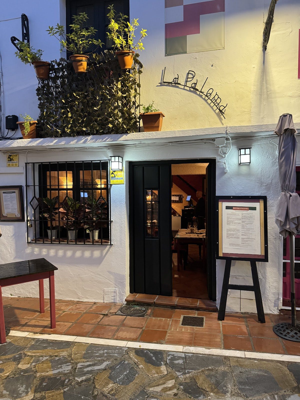 El Bistro Paloma cuenta con una encantadora entrada adornada con plantas en macetas y una acogedora zona de estar al aire libre.