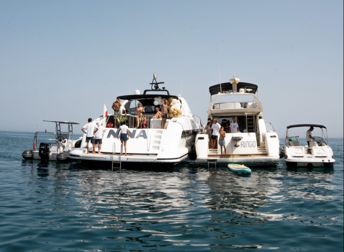 Un grupo de personas disfrutando del tiempo a bordo de yates de lujo en Blue Tide Marbella, en el agua.