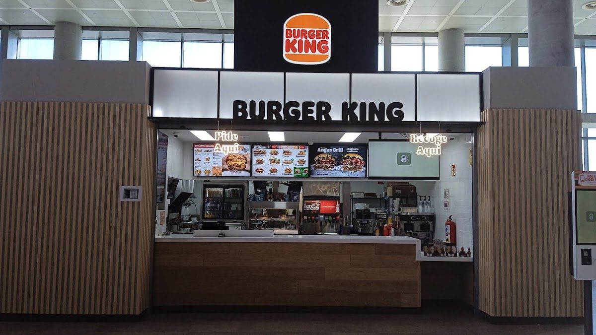 El Burger King Aeropuerto Málaga Tierra cuenta con un mostrador moderno con menús en pantalla y un interior acogedor.