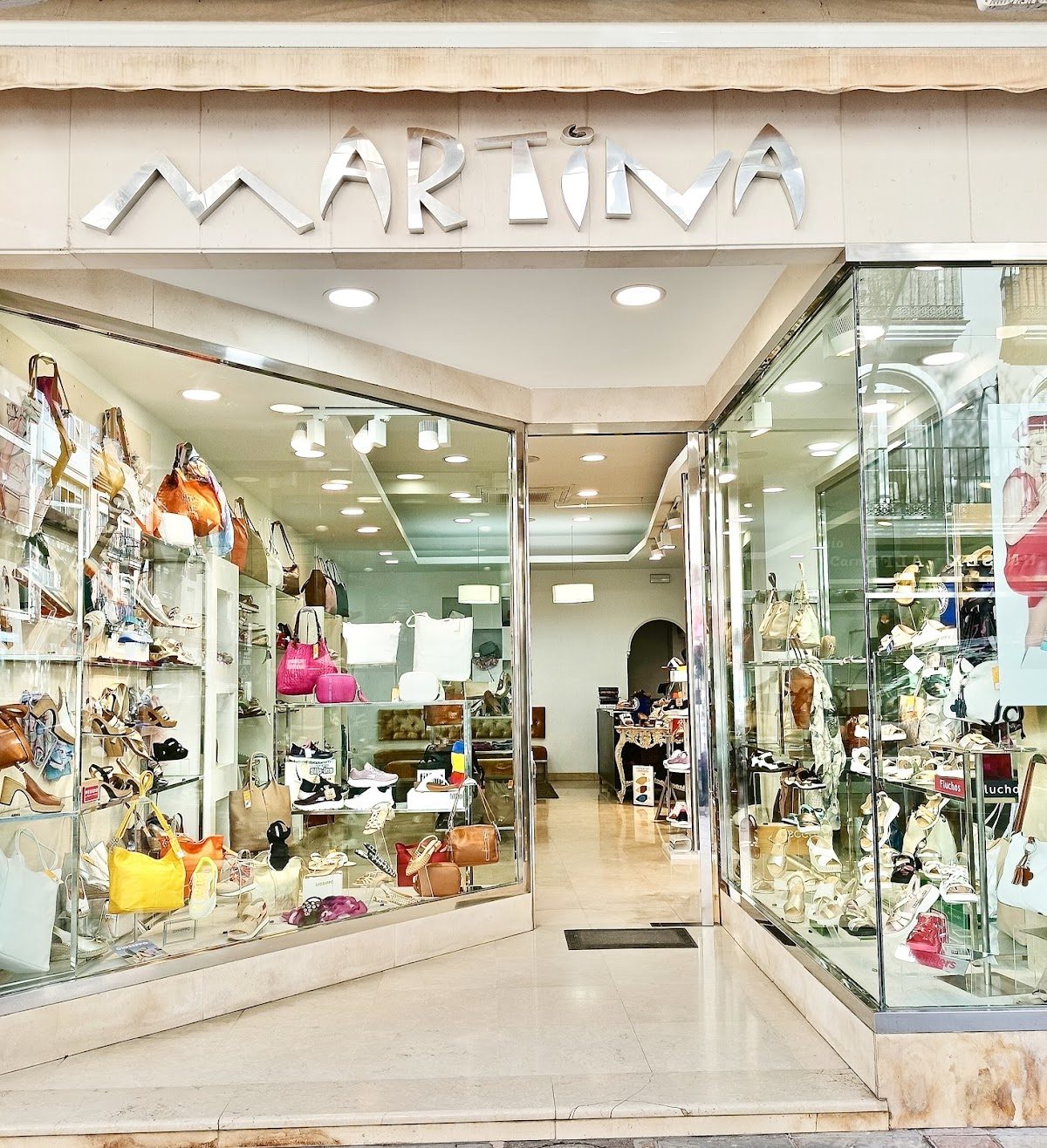 The storefront of Calzados Martina features a variety of shoes and bags displayed in glass cases.