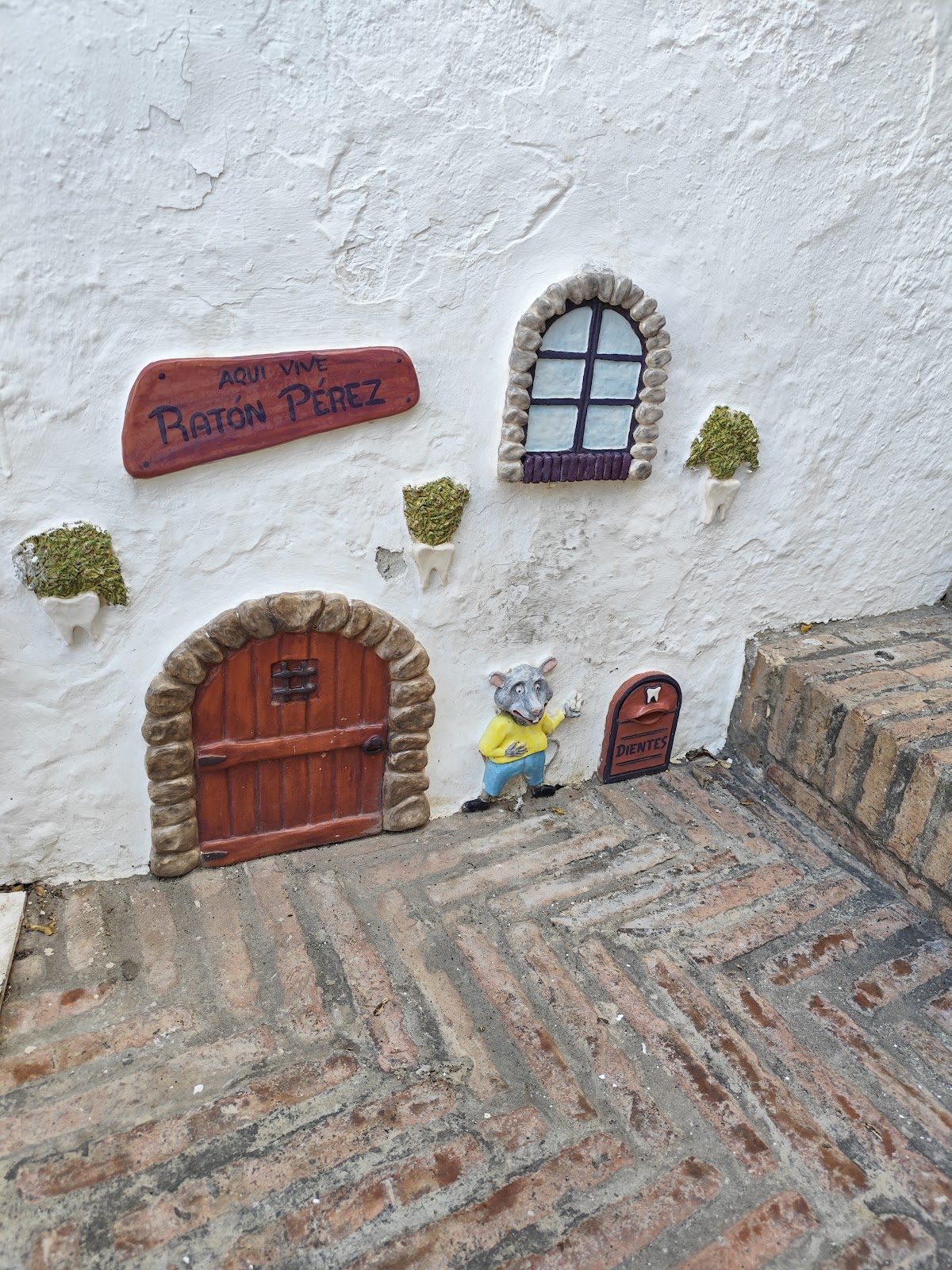 Una simpática figura de ratón y una puerta adornan la pared exterior de la Casa del Ratoncito Pérez en Torrox.
