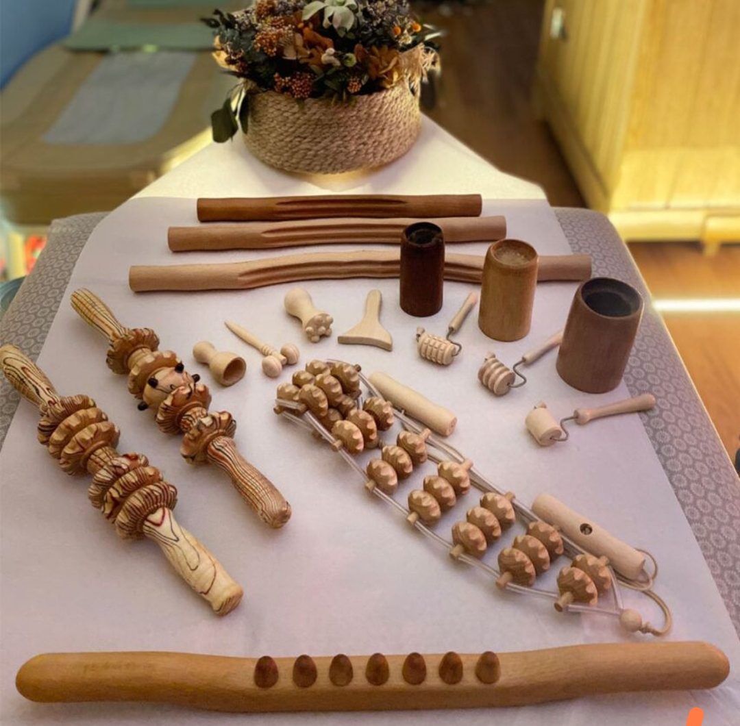 Various wooden massage tools displayed on a table at Centro Estético Luz De Vida in Cártama.