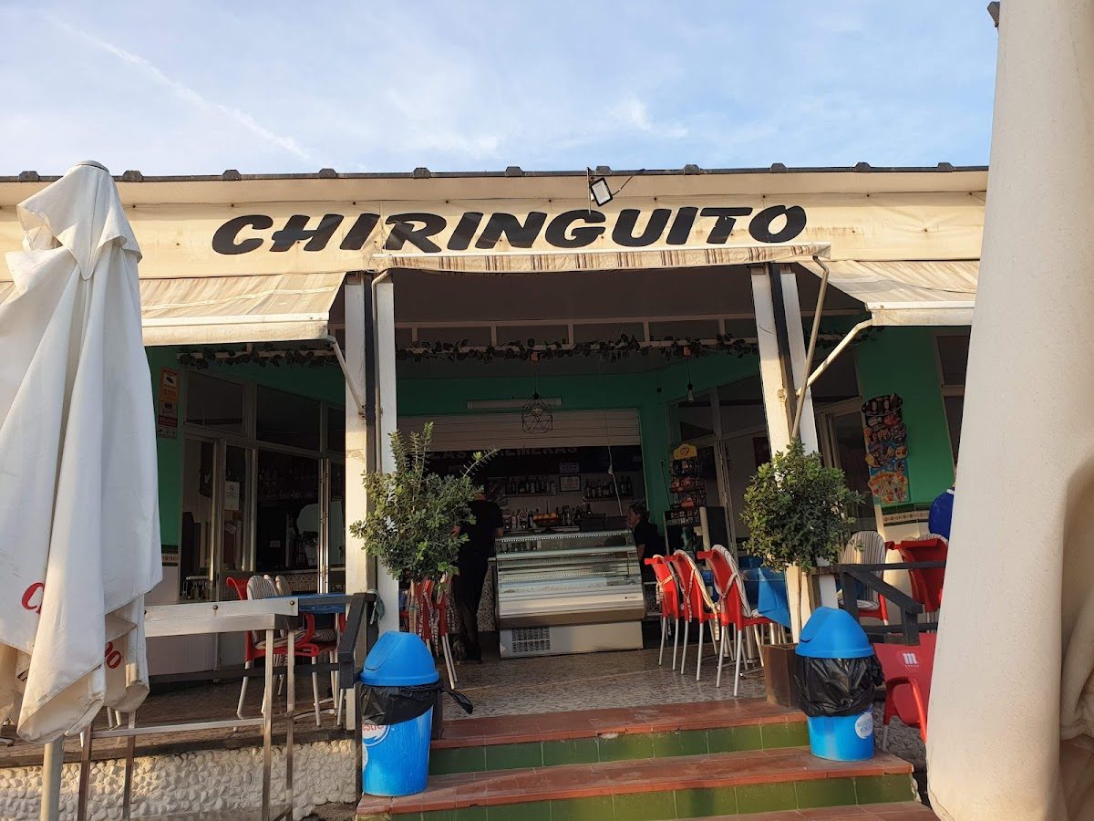 Chiringuito Las Palmeras features a casual outdoor dining area with colorful chairs and a beachside atmosphere.
