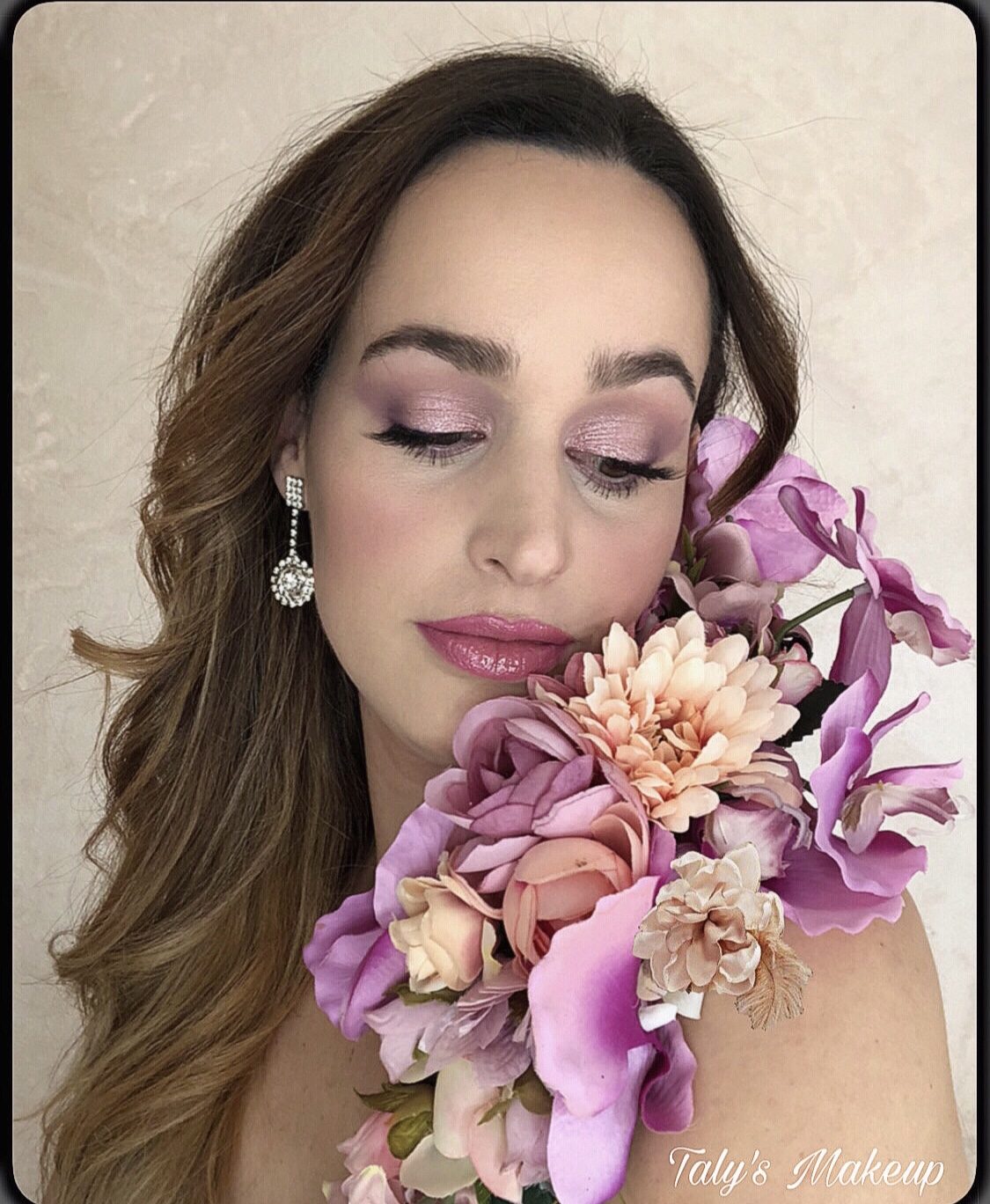 A woman poses elegantly with flowers, showcasing makeup artistry at Cirene centro de belleza.