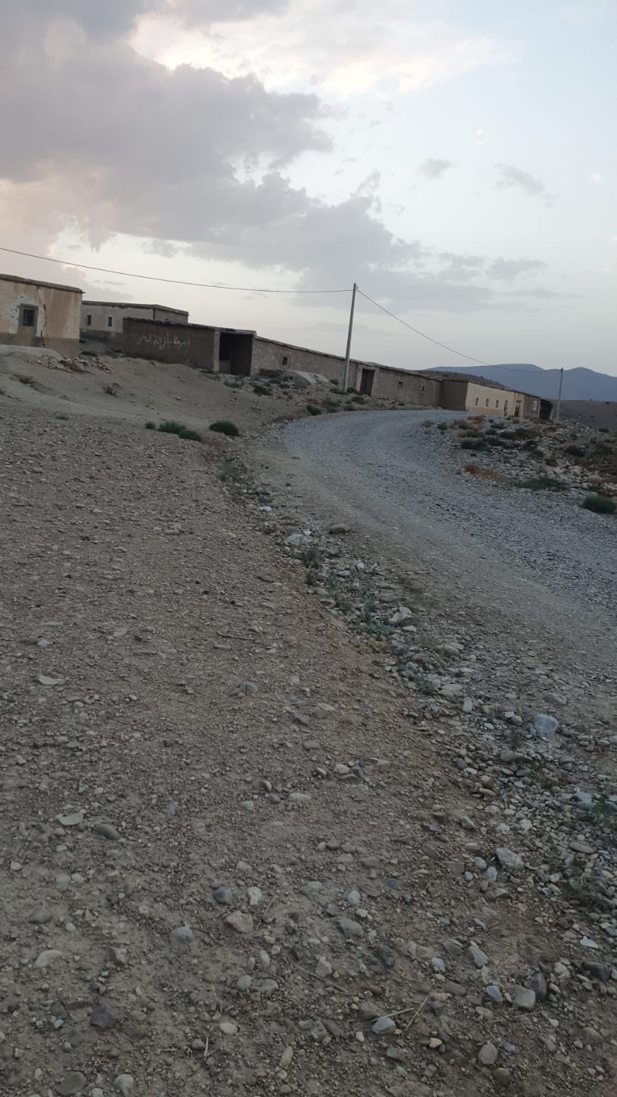 Camino de grava que conduce a una serie de construcciones rústicas en un paisaje árido cerca de Torremolinos.