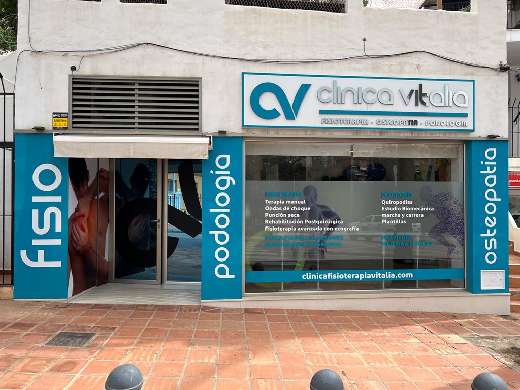 La Clínica Fisioterapia Vitalia Benalmádena presenta un exterior moderno con señalización para los servicios de fisioterapia, osteopatía y podología.
