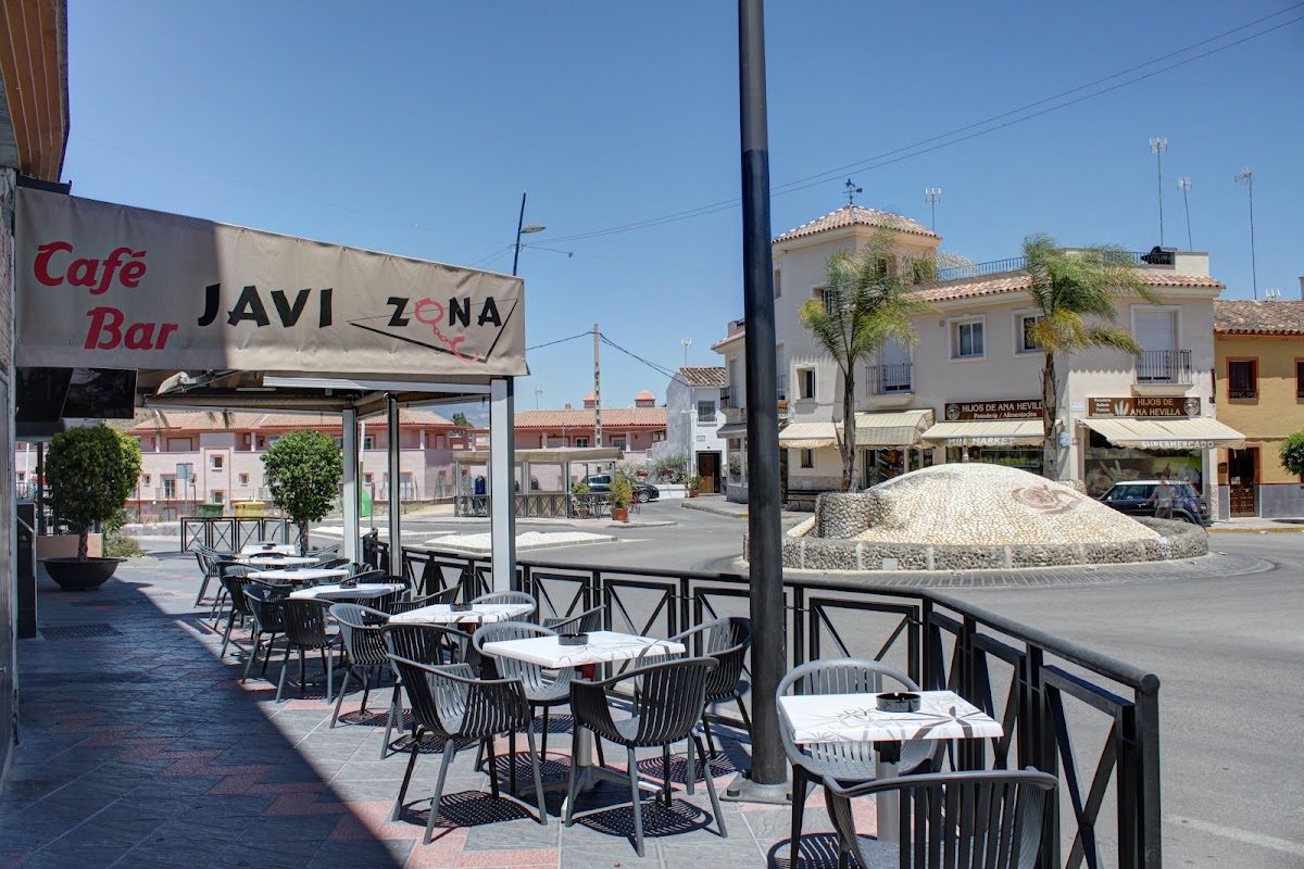 Outdoor seating area of Coffee Bar Javi Zone with tables and chairs along a street in Coín, Málaga.