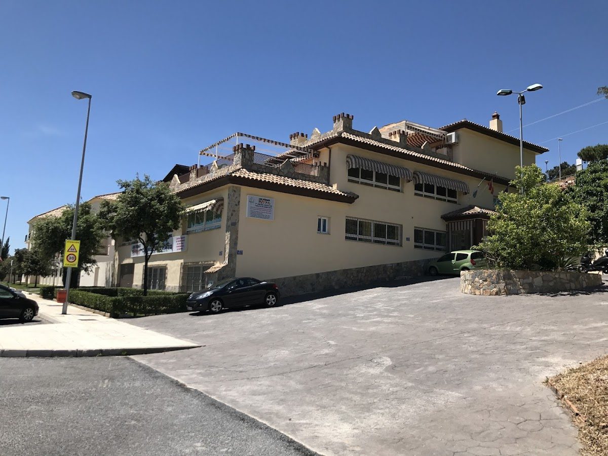 Cole Los Peques es un edificio espacioso con una entrada para vehículos en pendiente y zonas verdes a su alrededor, situado en Benalmádena.