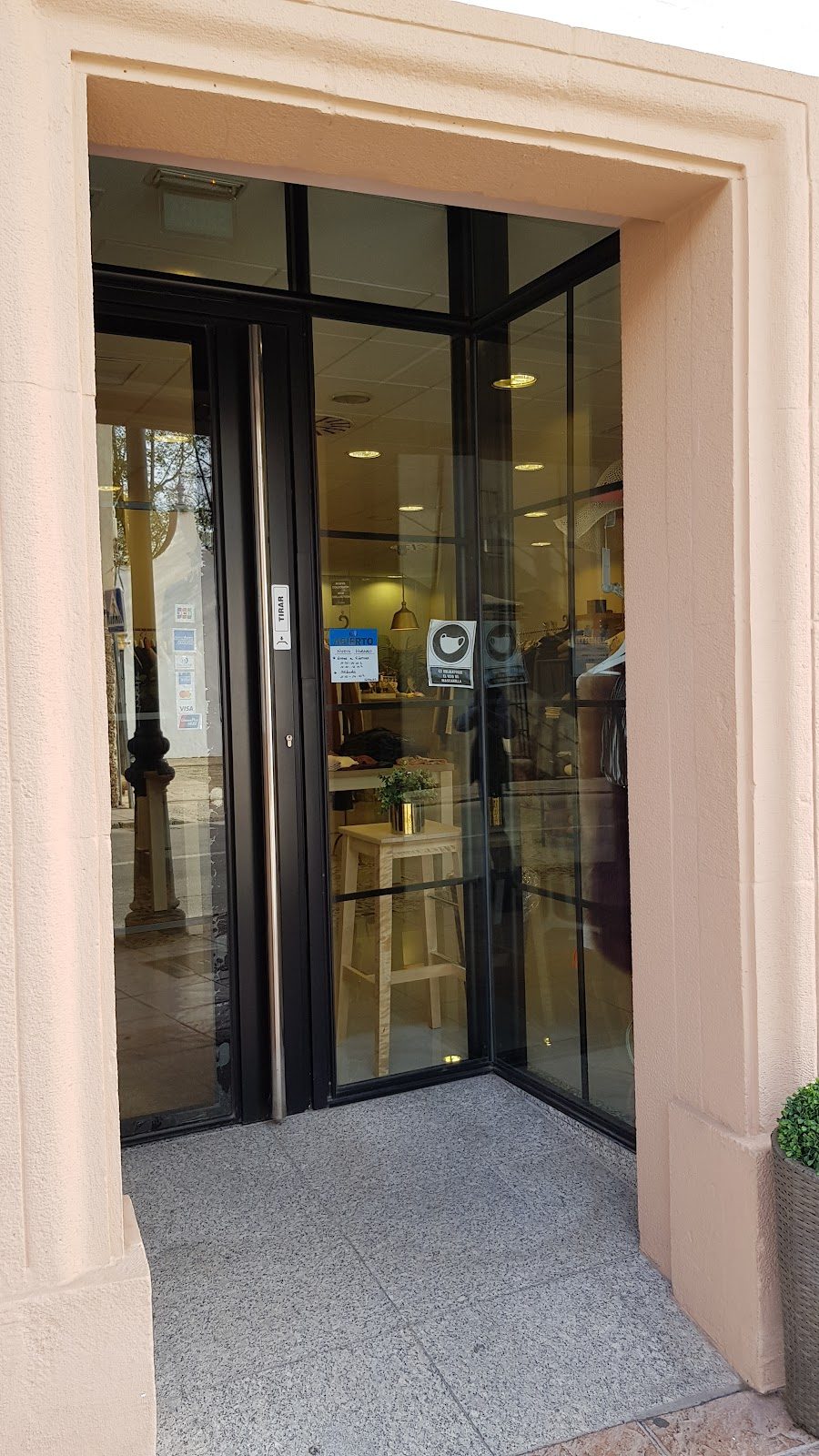 La entrada de Colette cuenta con una puerta de cristal y una pequeña zona de estar con una planta.