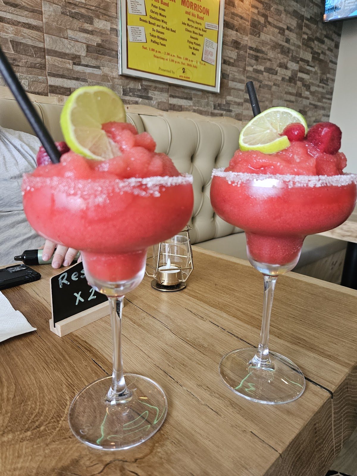 En Coopers Irish Bar & Café se sirven dos cócteles helados de colores vibrantes, adornados con lima y frambuesa.