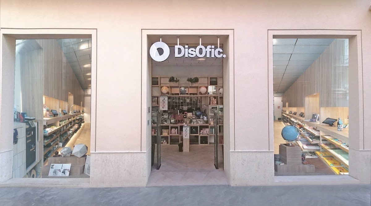 La entrada del DisOfic Center cuenta con grandes ventanales que permiten ver una variedad de productos en el interior.