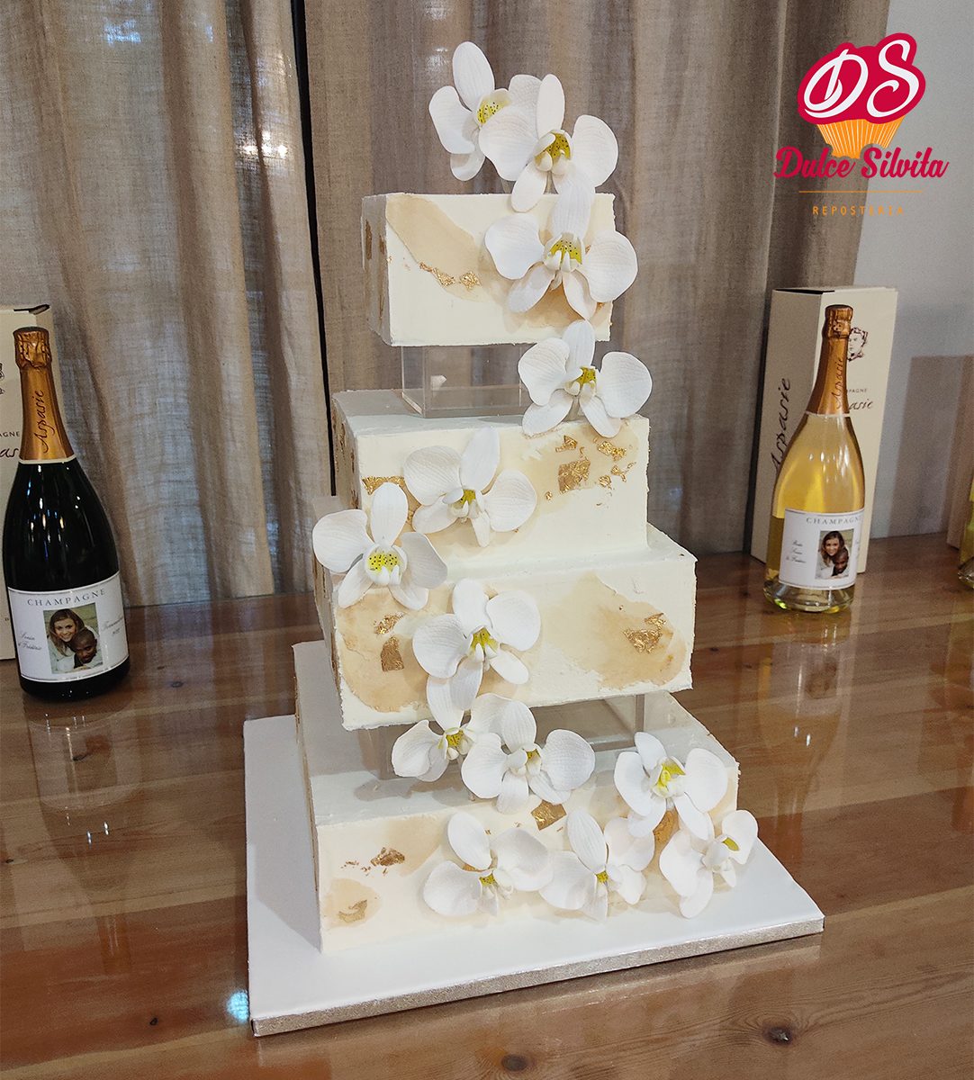 A beautifully designed wedding cake adorned with white orchids at Dulce Silvita.