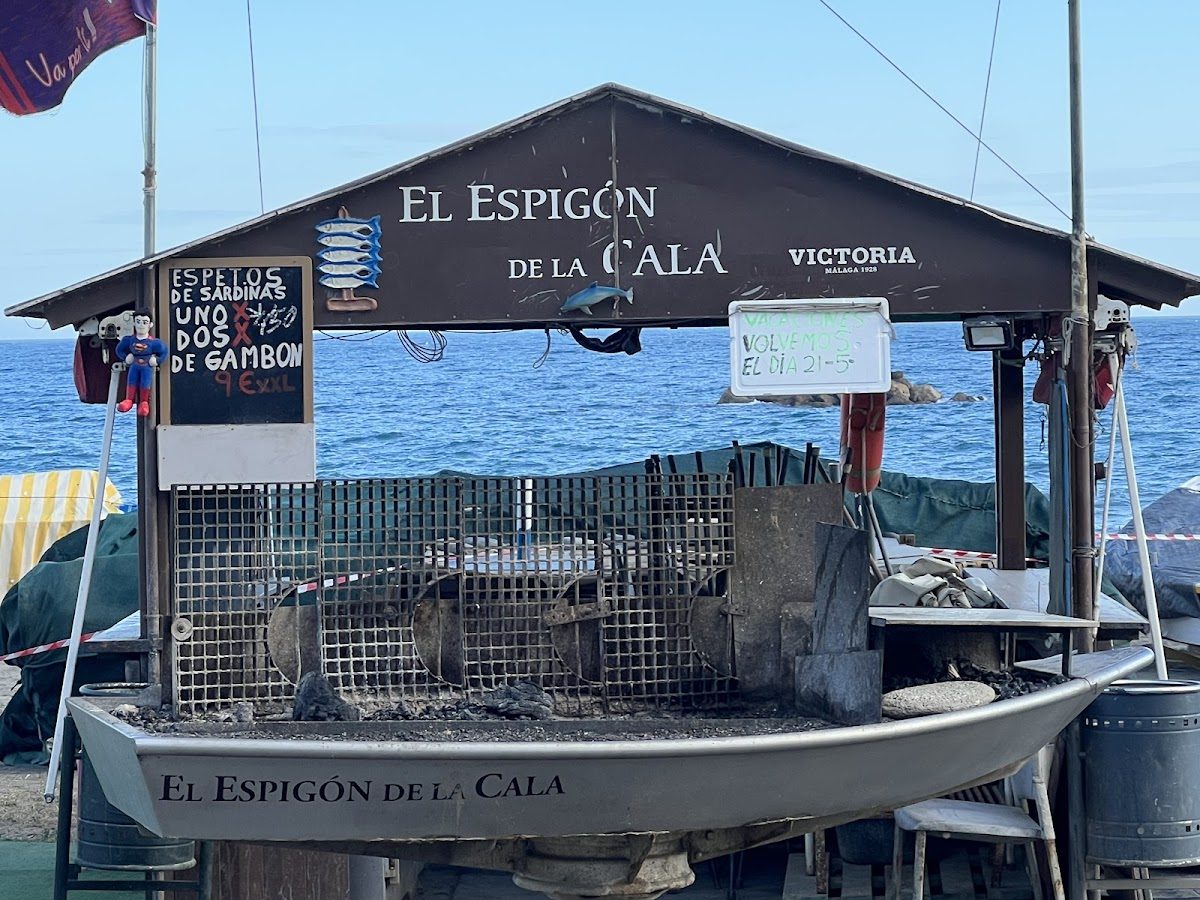 El Espigón de La Cala cuenta con una parrilla de marisco instalada junto al mar, con un cartel que muestra los platos del menú.