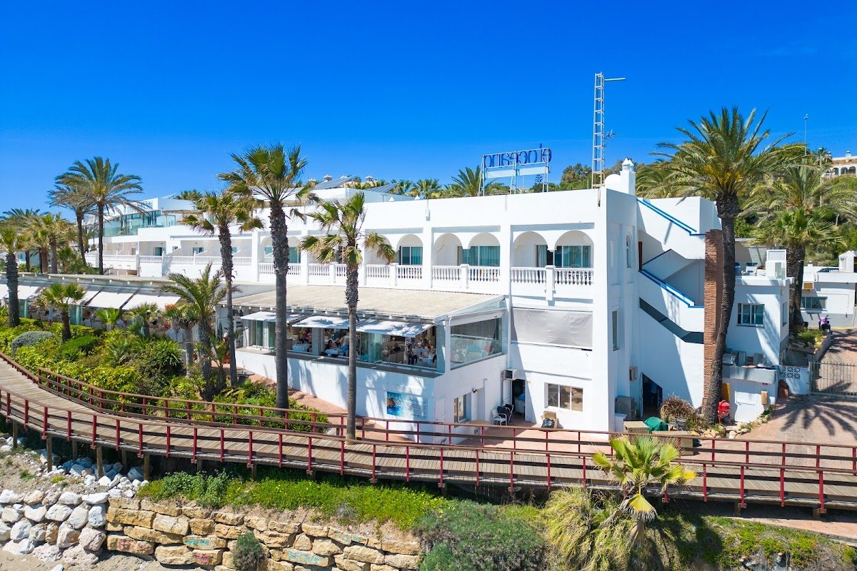 El Oceano Beach Hotel & Restaurant presenta un exterior moderno con palmeras y vistas a la playa.