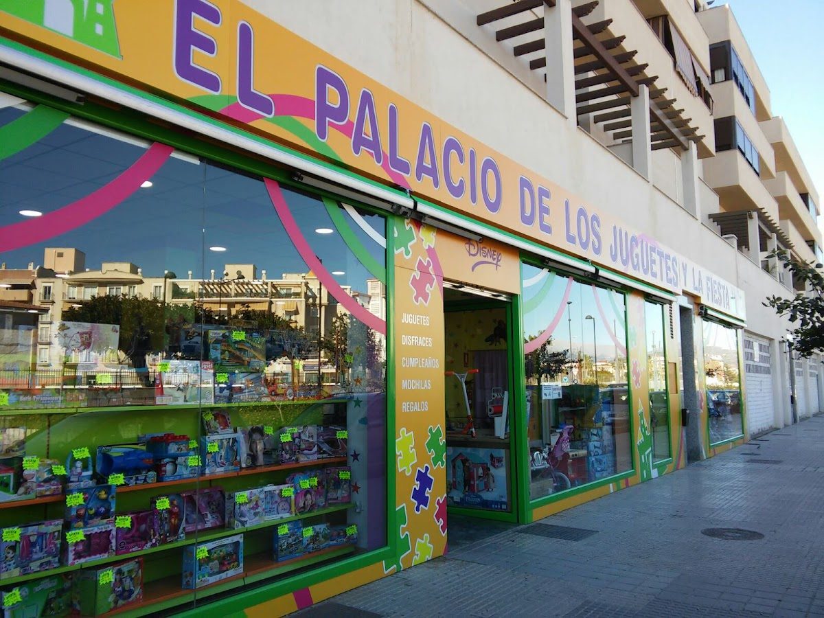 Colorful storefront of El Palacio de los juguetes y la fiesta, featuring toys and party supplies.