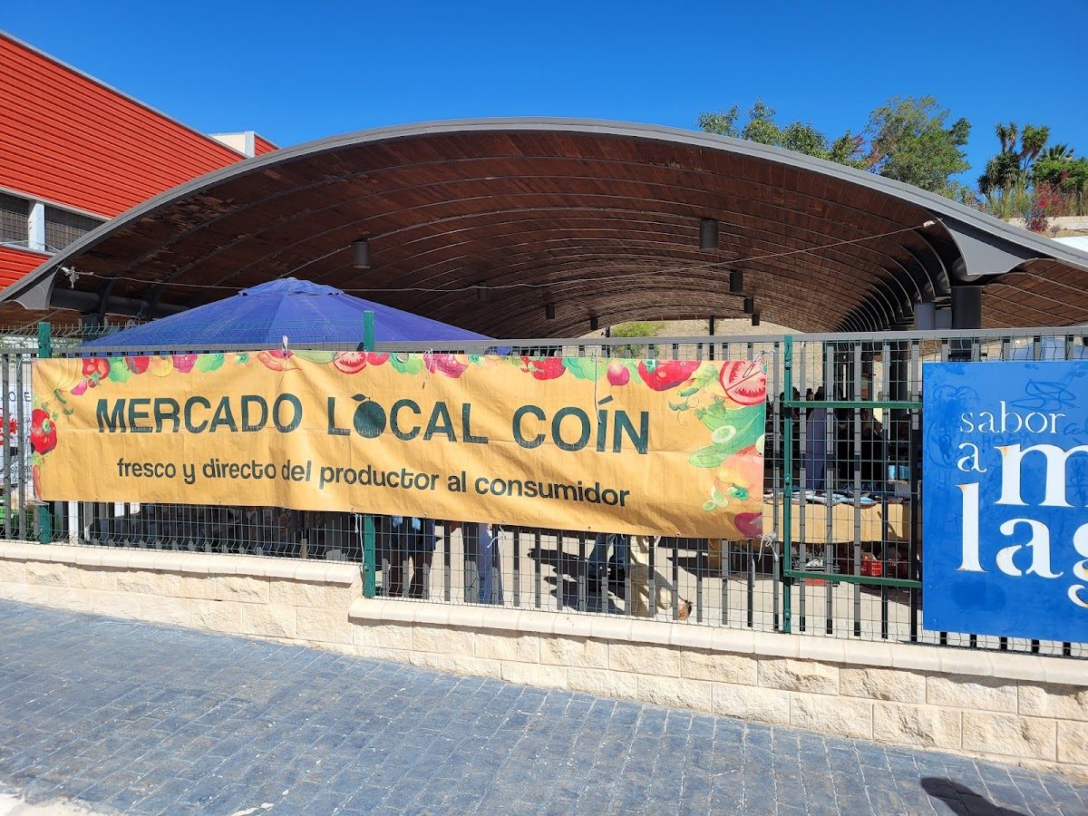 El Rincón de la Plaza features a vibrant outdoor market banner promoting local produce.