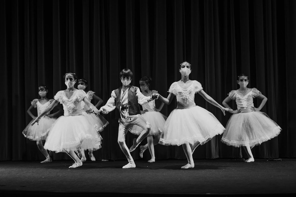 A group of young ballet dancers performing on stage in elegant costumes at El Taller del Arte.