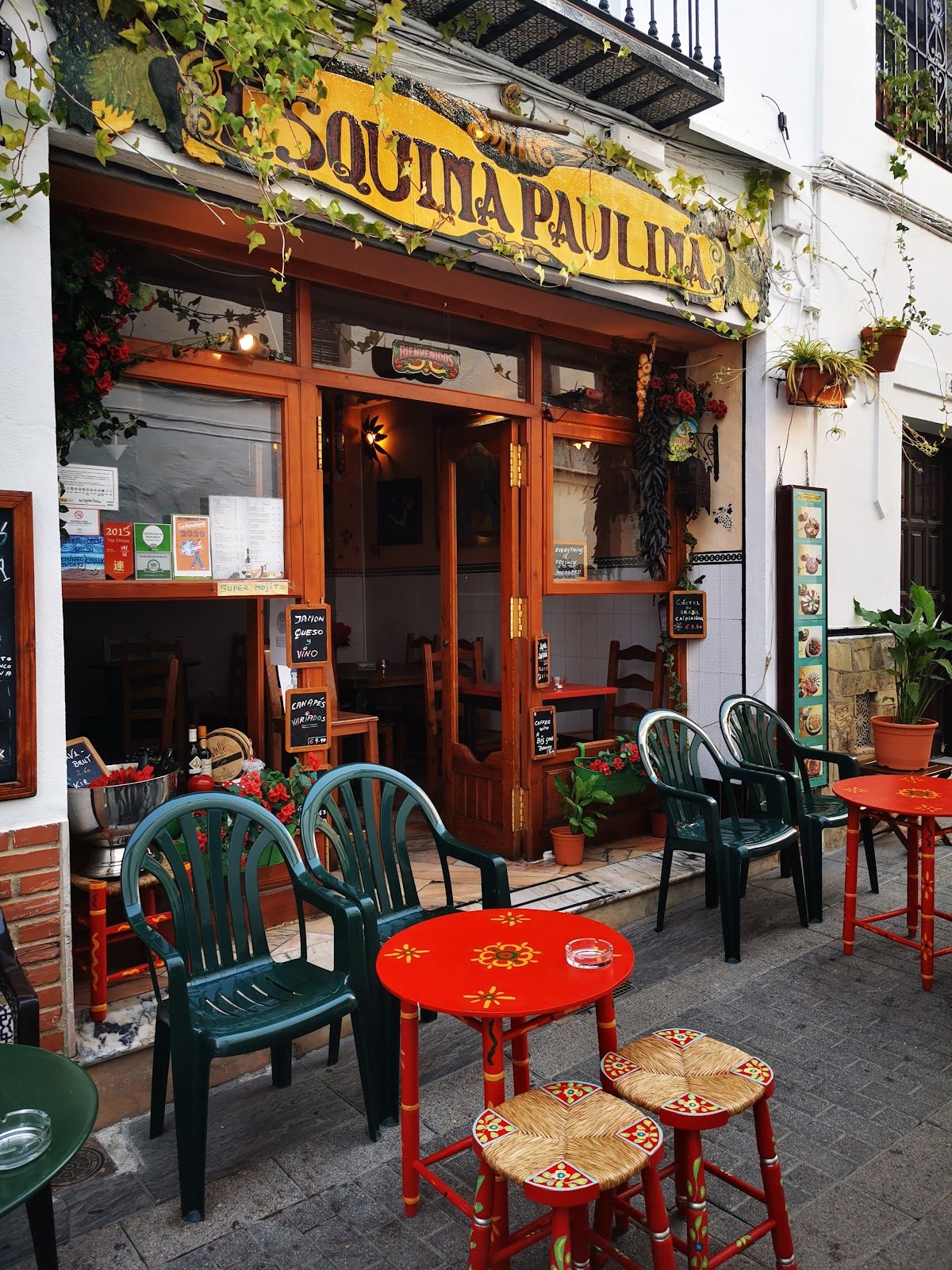 Esquina Paulina features a charming outdoor seating area with colorful tables and chairs.