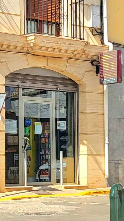 Estanco N 1 features a glass entrance with various products visible inside, located on a street corner.