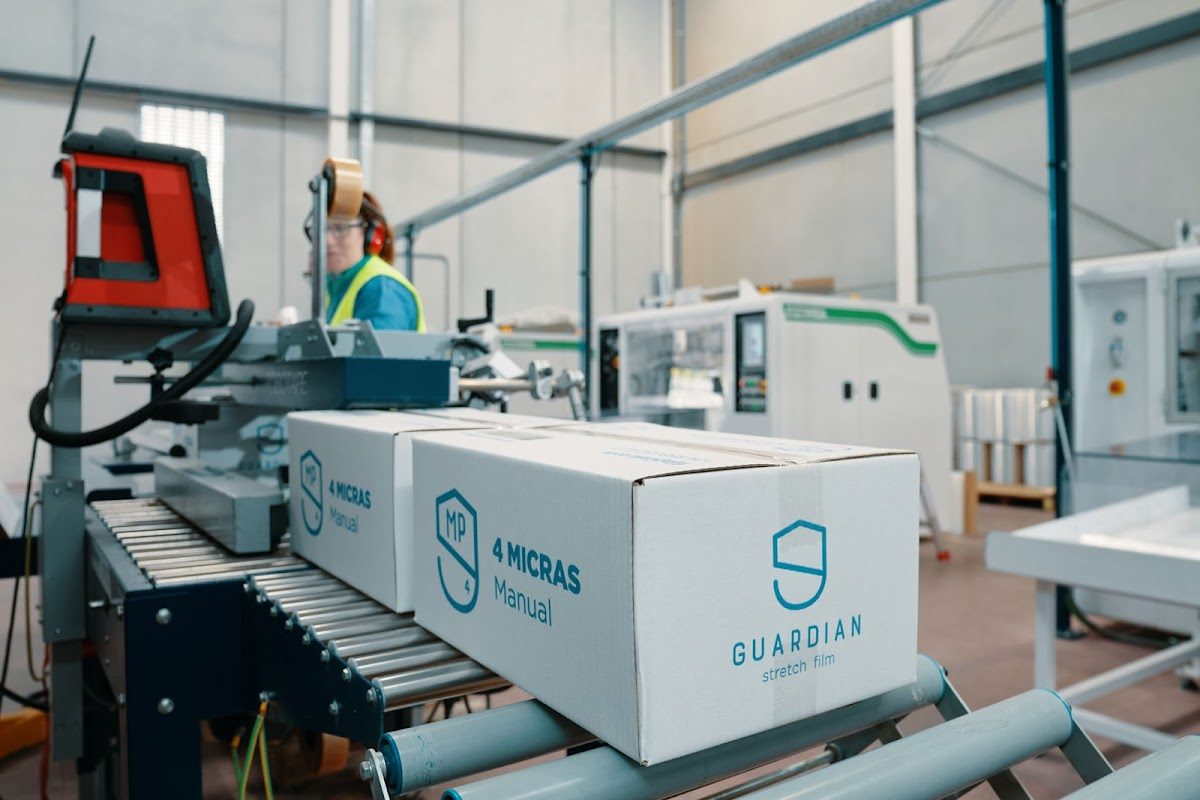 Vista interior de la planta de Fijaplast S.L.U. que muestra el equipo de embalaje y las cajas de film estirable Guardian.