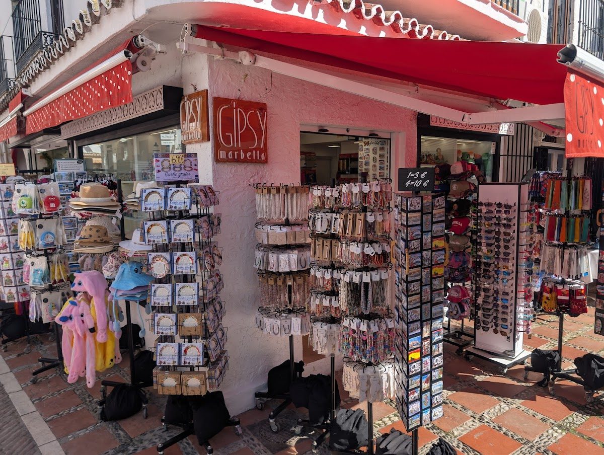 Gipsy Marbella Plaza Souvenirs ofrece una variedad de recuerdos expuestos en el exterior, incluyendo sombreros, joyas y peluches.