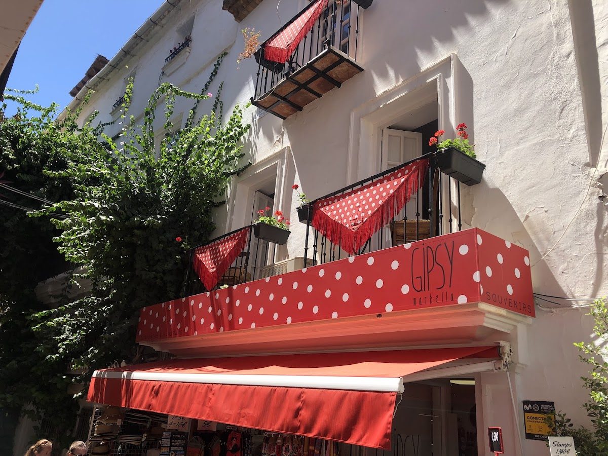 El exterior de Gipsy Marbella Souvenirs cuenta con un toldo de lunares y coloridas jardineras.